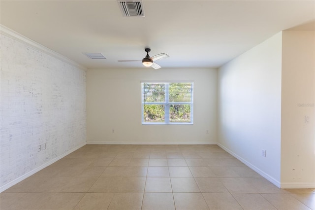 tiled spare room with ceiling fan and brick wall