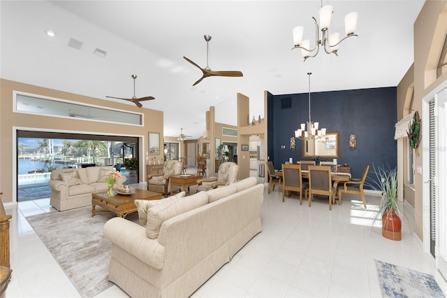 tiled living room with a water view, high vaulted ceiling, and ceiling fan with notable chandelier