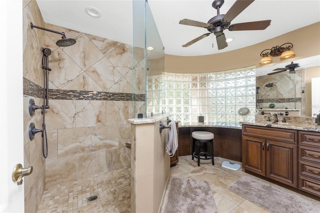 bathroom with ceiling fan, vanity, and a tile shower