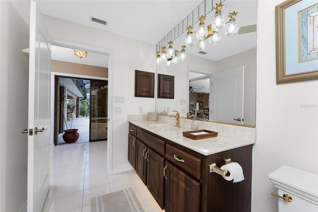 bathroom featuring tile patterned flooring, vanity, ceiling fan, and toilet