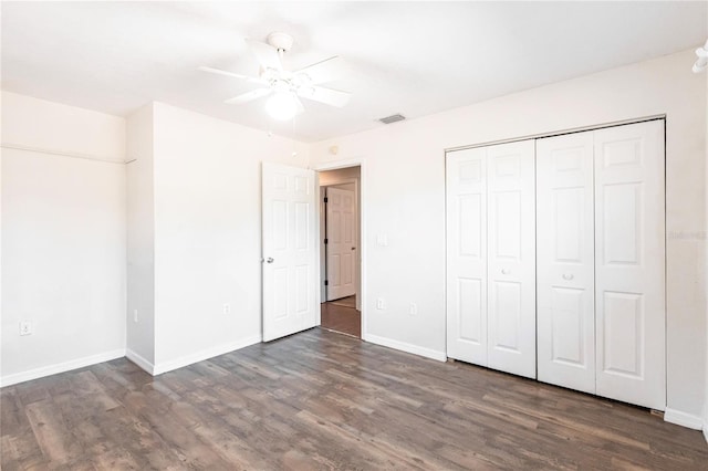 unfurnished bedroom with dark hardwood / wood-style flooring, a closet, and ceiling fan