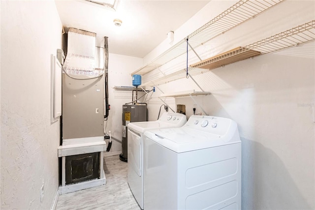 clothes washing area with electric water heater and washer and clothes dryer