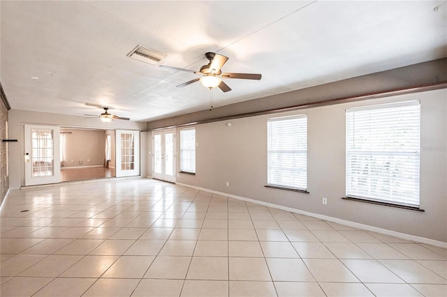 unfurnished room featuring ceiling fan, a healthy amount of sunlight, and light tile patterned floors