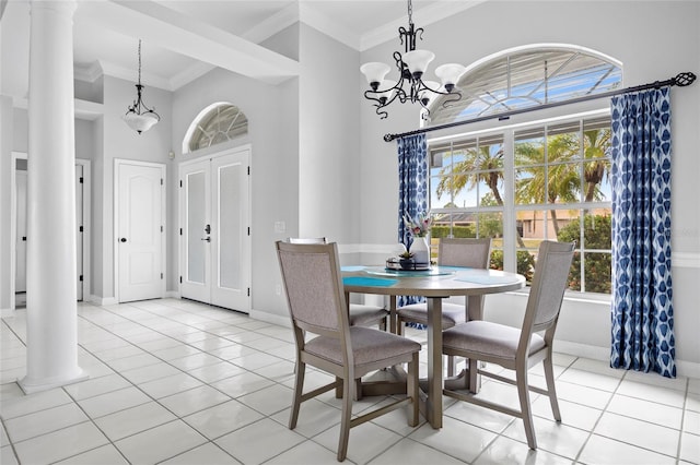 dining area with a towering ceiling, ornamental molding, decorative columns, and light tile patterned floors