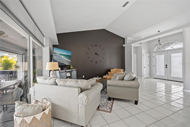 tiled living room featuring lofted ceiling and french doors