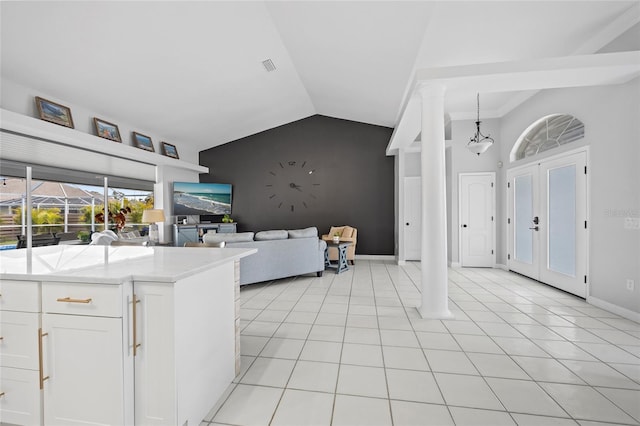 kitchen with white cabinetry, lofted ceiling, light tile patterned floors, and decorative light fixtures