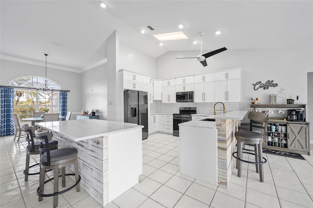 kitchen featuring pendant lighting, a kitchen breakfast bar, stainless steel appliances, white cabinets, and kitchen peninsula