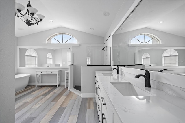 bathroom with lofted ceiling, vanity, hardwood / wood-style flooring, and independent shower and bath