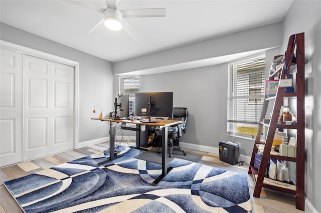 home office with ceiling fan, plenty of natural light, and light wood-type flooring