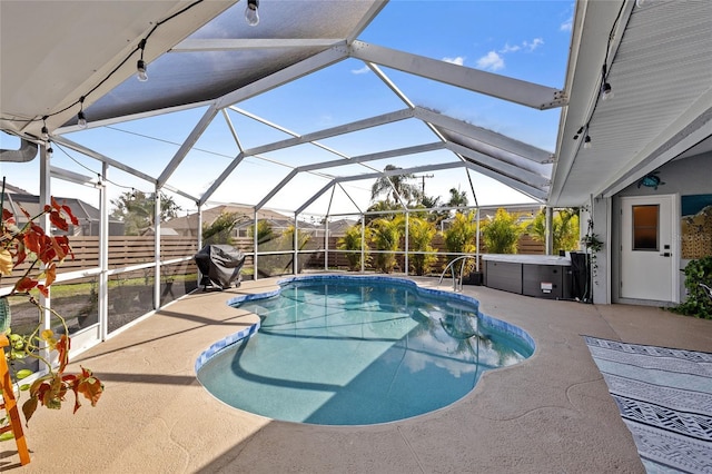 view of pool with grilling area, a lanai, a patio area, and a hot tub