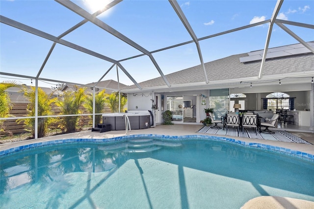 view of pool with a hot tub, a patio area, and glass enclosure