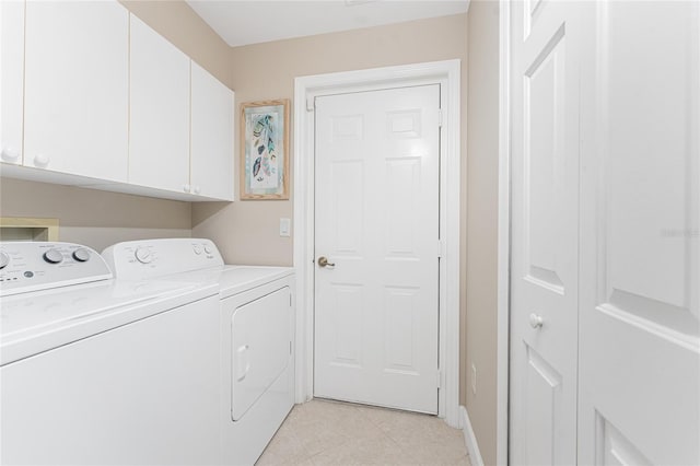 laundry area with separate washer and dryer and cabinets