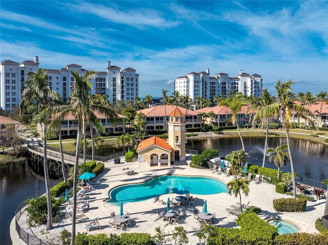 view of swimming pool featuring a patio and a water view