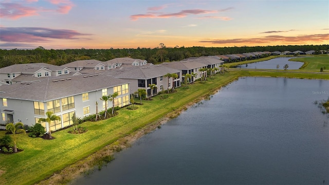 aerial view at dusk featuring a water view