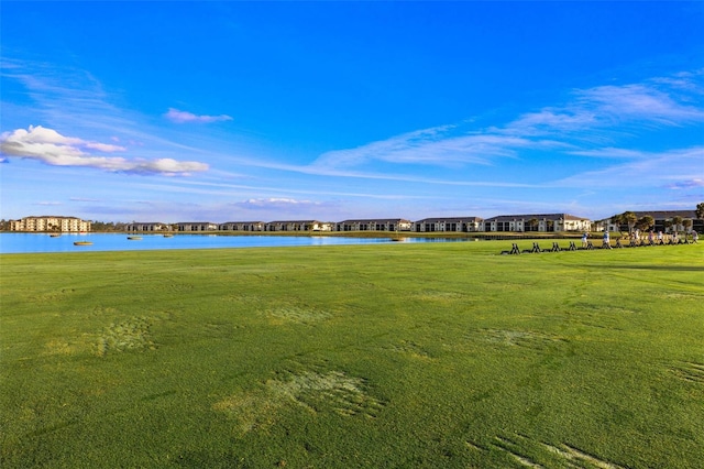 view of home's community with a water view and a lawn