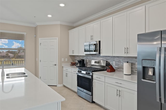 kitchen featuring white cabinetry, ornamental molding, appliances with stainless steel finishes, and sink