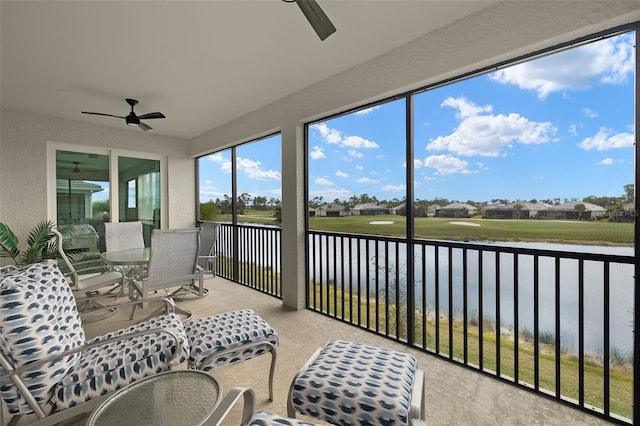 sunroom / solarium featuring a water view and ceiling fan