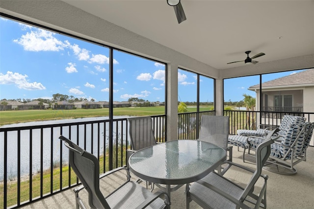 sunroom / solarium with a water view and ceiling fan