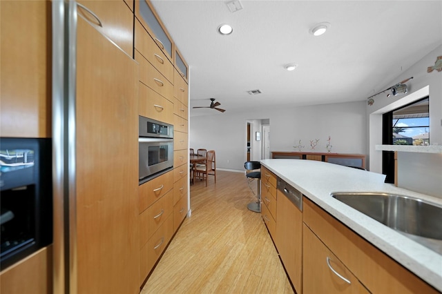 kitchen with light hardwood / wood-style flooring, ceiling fan, and appliances with stainless steel finishes