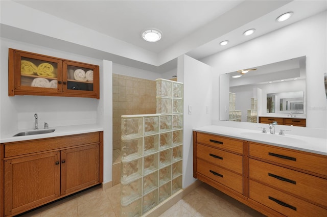 bathroom with vanity, a tile shower, and tile patterned floors