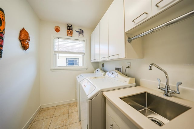 laundry room with cabinets, washing machine and clothes dryer, light tile patterned flooring, and sink