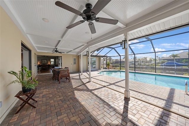 view of pool with a patio, ceiling fan, and glass enclosure