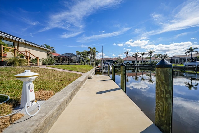 dock area with a water view and a yard