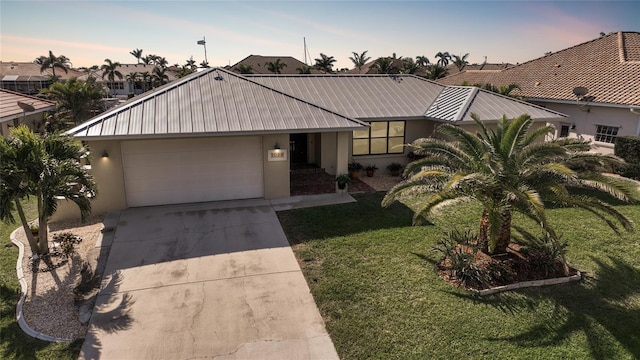 single story home with a garage and a lawn