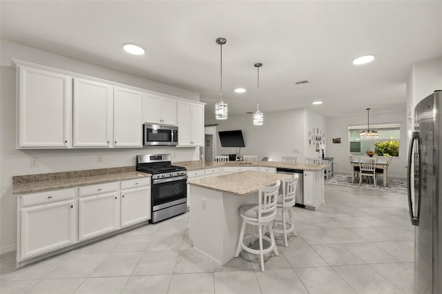 kitchen featuring white cabinetry, a center island, appliances with stainless steel finishes, and kitchen peninsula