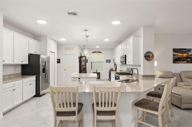 kitchen featuring pendant lighting, sink, a breakfast bar, stainless steel appliances, and kitchen peninsula