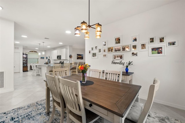 tiled dining space featuring an inviting chandelier