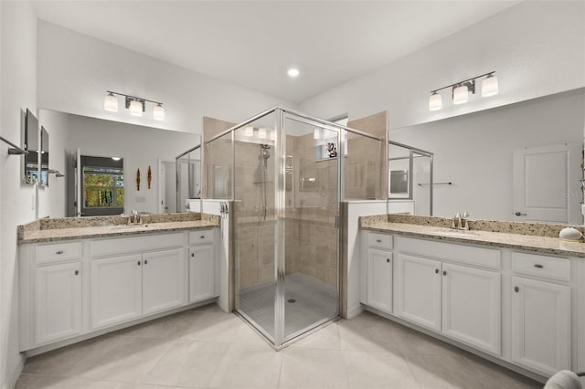 bathroom featuring vanity, a shower with shower door, and tile patterned flooring