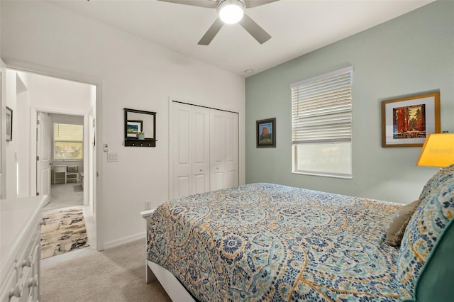 bedroom featuring light colored carpet, a closet, and ceiling fan