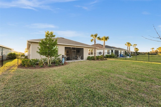 rear view of property featuring a sunroom and a lawn