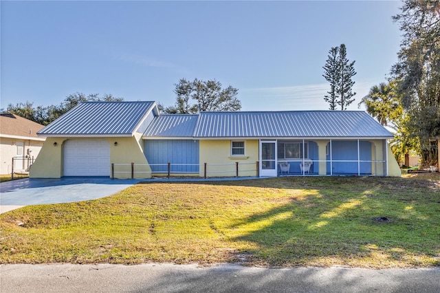 ranch-style home featuring a garage, a sunroom, and a front lawn