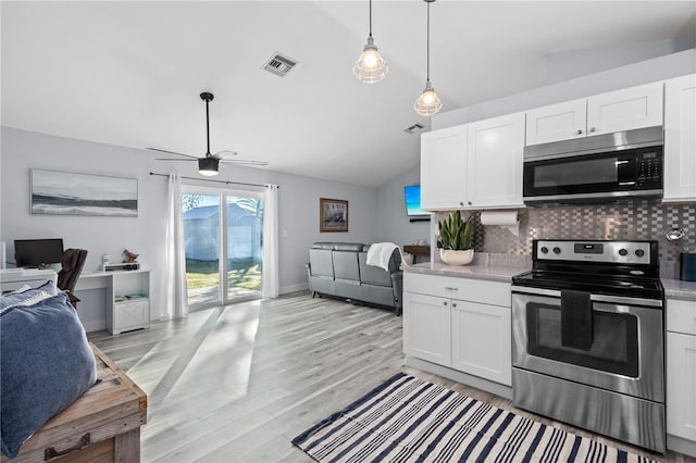 kitchen with vaulted ceiling, white cabinetry, and appliances with stainless steel finishes