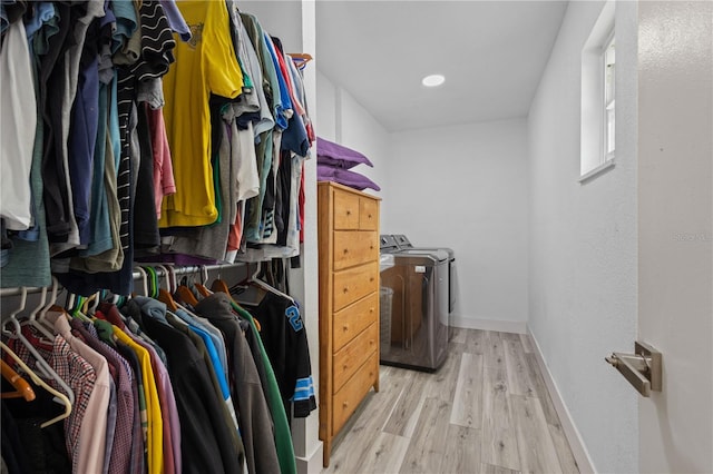 spacious closet featuring light hardwood / wood-style flooring and washer and clothes dryer