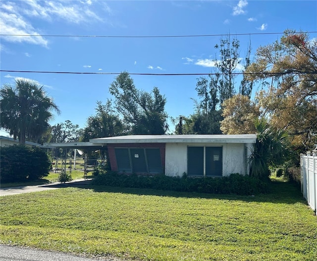 view of front of property with a front yard and a carport