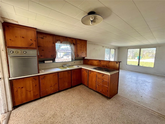 kitchen featuring sink, a wealth of natural light, cooktop, and stainless steel oven