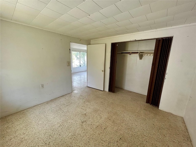 unfurnished bedroom featuring ornamental molding and a closet