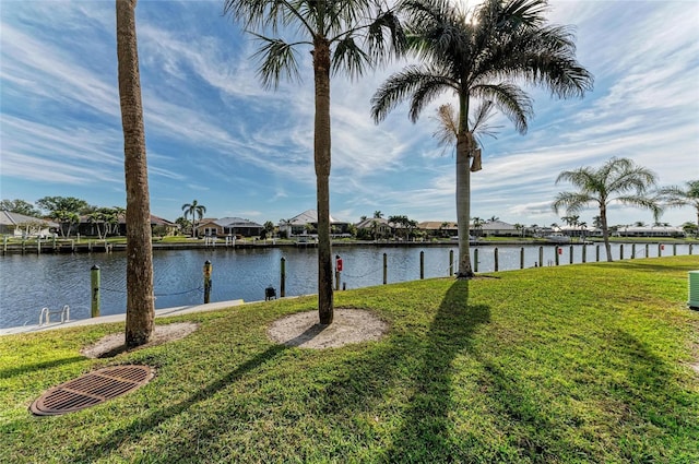 view of yard with a water view and a boat dock