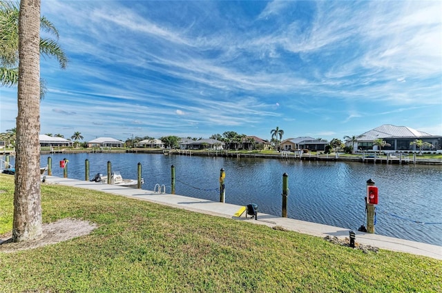 view of dock with a lawn and a water view