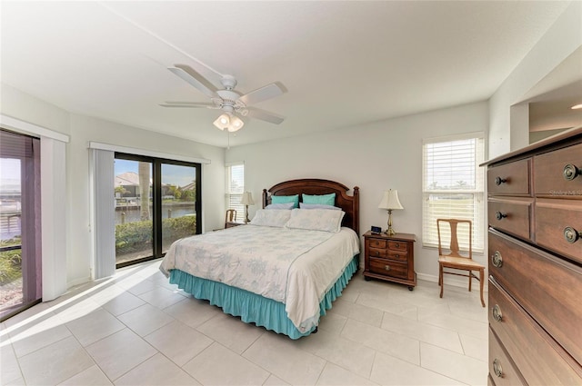 tiled bedroom featuring multiple windows, a water view, access to outside, and ceiling fan