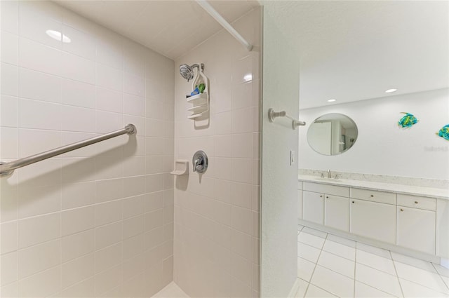 bathroom featuring tile patterned flooring, vanity, and a tile shower