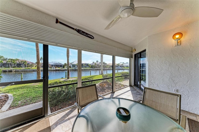 sunroom / solarium with a water view and ceiling fan