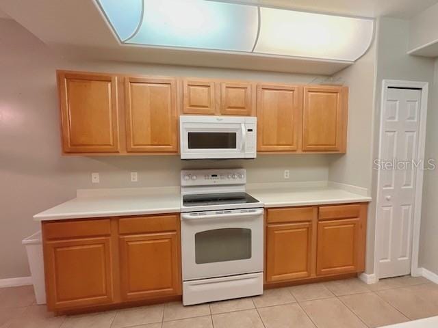 kitchen featuring light tile patterned floors and white appliances