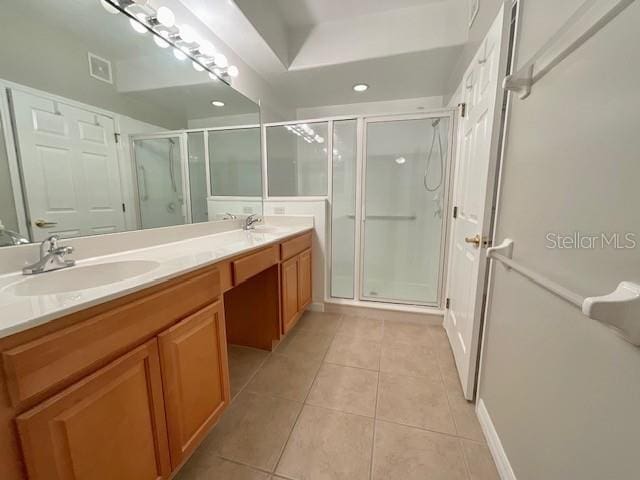 bathroom with walk in shower, vanity, and tile patterned flooring