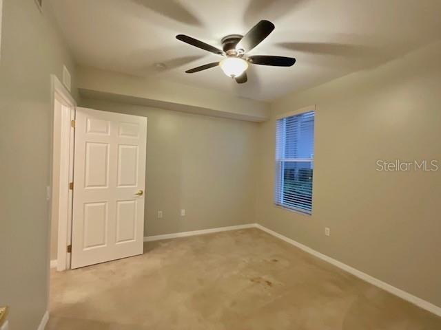 carpeted empty room with ceiling fan