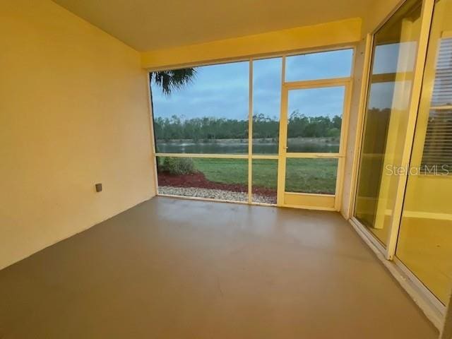 unfurnished sunroom with a healthy amount of sunlight and a water view