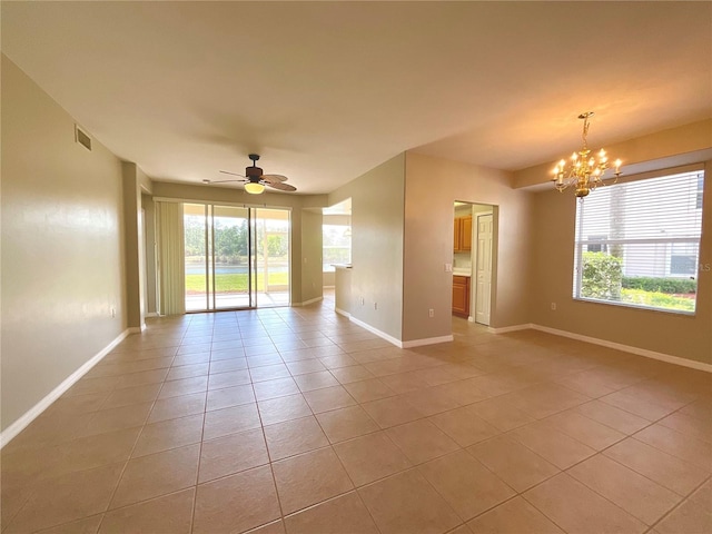 unfurnished room featuring light tile patterned flooring and ceiling fan with notable chandelier